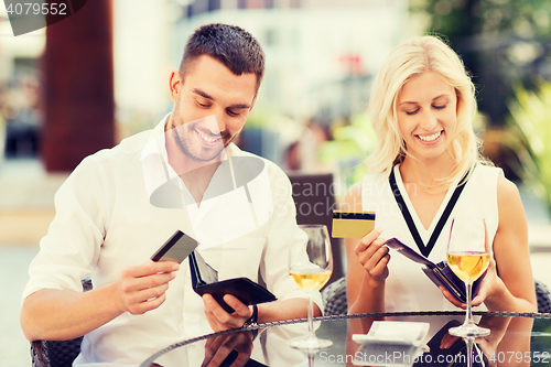 Image of couple with credit cards paying bill at restaurant