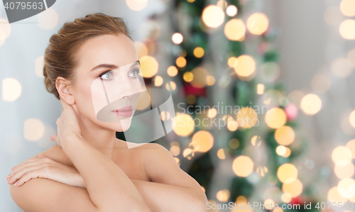 Image of beautiful young woman over christmas lights