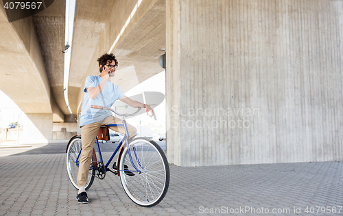 Image of man with smartphone and fixed gear bike on street