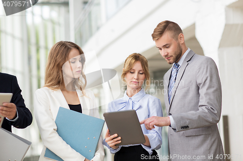 Image of business team with tablet pc and folders at office