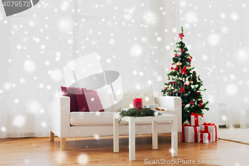 Image of sofa, table and christmas tree with gifts at home