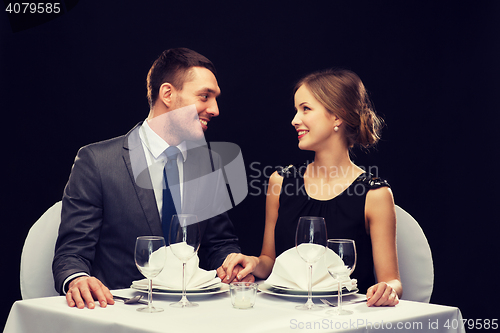 Image of smiling couple looking at each other at restaurant