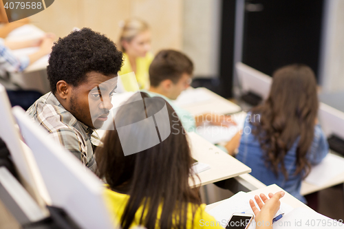 Image of group of students talking in lecture hall