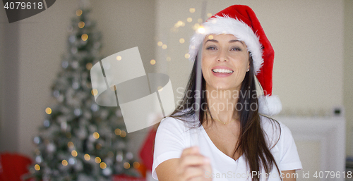 Image of Festive young woman in red Santa Claus hat