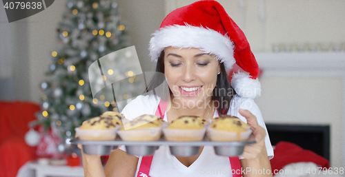Image of Smiling woman with a tray of freshly baked cakes
