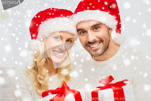 Image of happy couple at home with christmas gift boxes