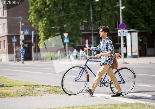 Image of young man with fixed gear bicycle on crosswalk