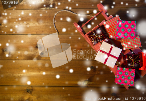 Image of close up of christmas gift boxes on wooden sleigh