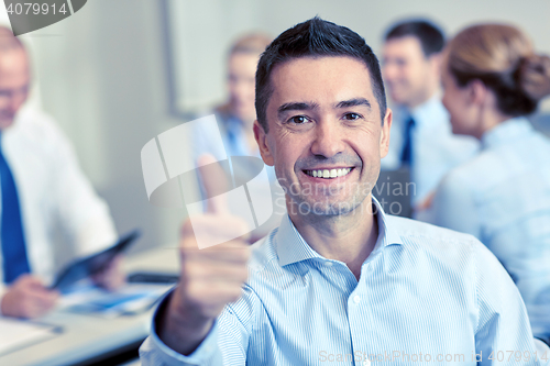 Image of group of smiling businesspeople meeting in office