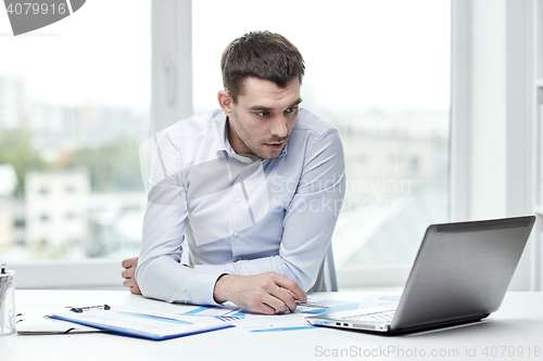 Image of stressed businessman with laptop at office