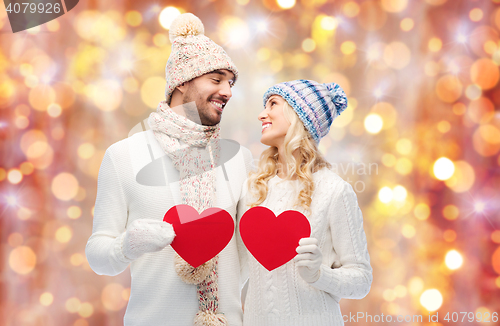 Image of smiling couple in winter clothes with red hearts