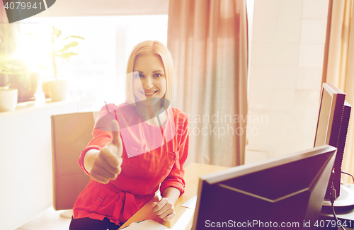 Image of happy creative female office worker with computers