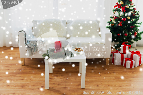 Image of sofa, table and christmas tree with gifts at home