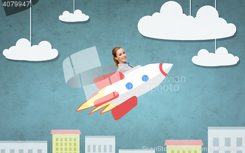 Image of businesswoman flying on rocket above cartoon city