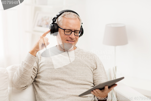 Image of senior man with tablet pc and headphones at home