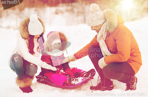 Image of happy family with sled walking in winter forest