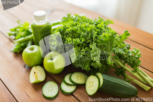 Image of close up of bottle with green juice and vegetables