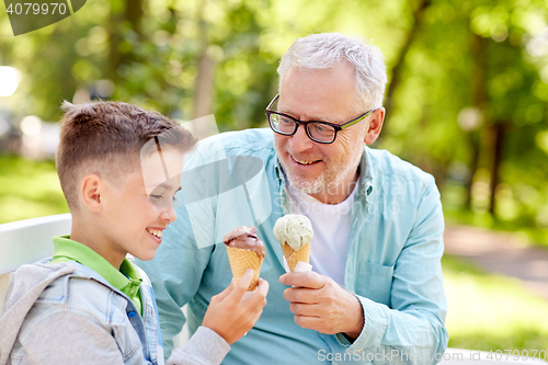 Image of old man and boy eating ice cream at summer park