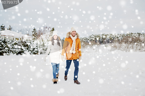 Image of happy couple walking along snowy winter field