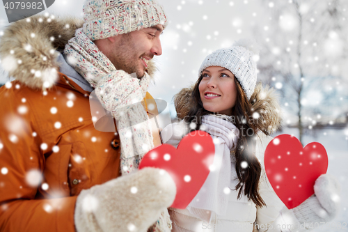 Image of happy couple with red hearts over winter landscape