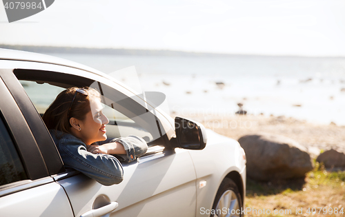 Image of happy teenage girl or young woman in car