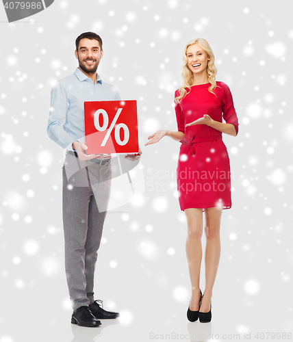 Image of happy couple with red sale sign over snow