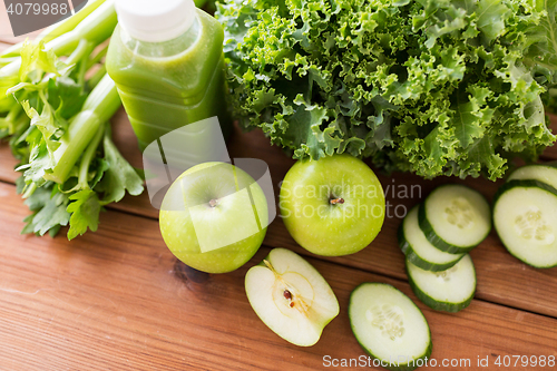 Image of close up of bottle with green juice and vegetables