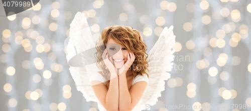Image of happy young woman or teen girl with angel wings