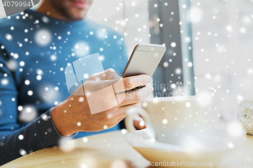 Image of close up of man with smartphones at cafe