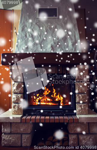 Image of close up of burning fireplace with snow