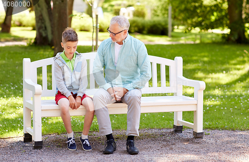 Image of grandfather and grandson talking at summer park