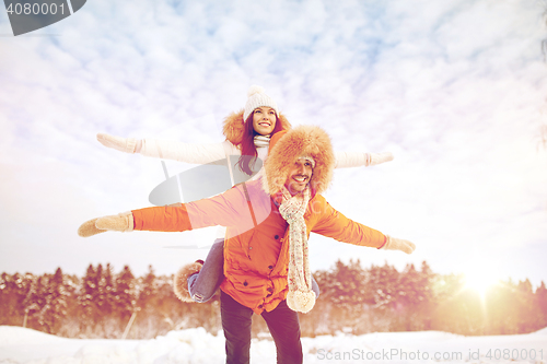 Image of happy couple having fun over winter background