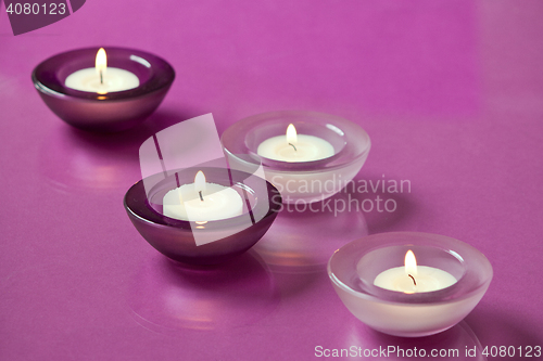 Image of burning candles on purple background