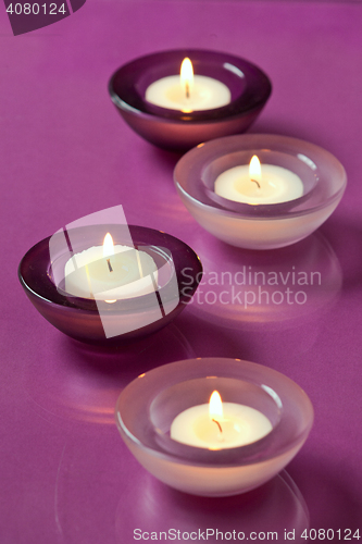 Image of burning candles on purple background