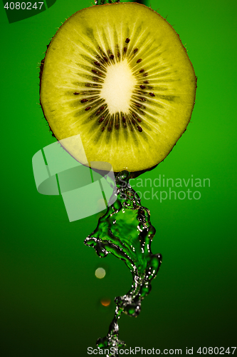 Image of Ripe kiwifruit with drops of water isolated on green background