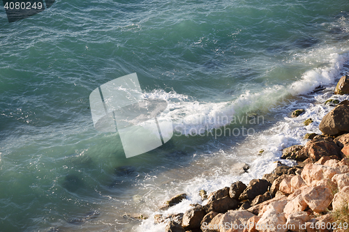 Image of Rocky cliffs and turquoise sea water on sunny day