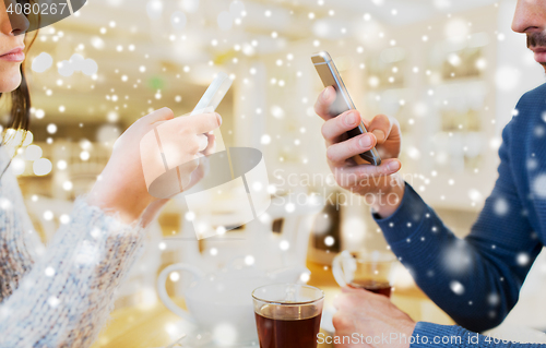 Image of close up of couple with smartphones at cafe