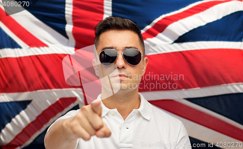 Image of man in shades pointing finger over brittish flag