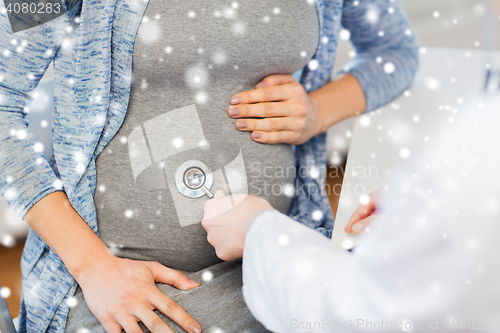 Image of doctor with stethoscope and pregnant woman belly