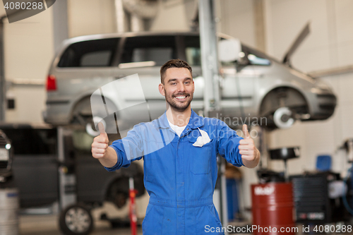 Image of happy auto mechanic man or smith at car workshop