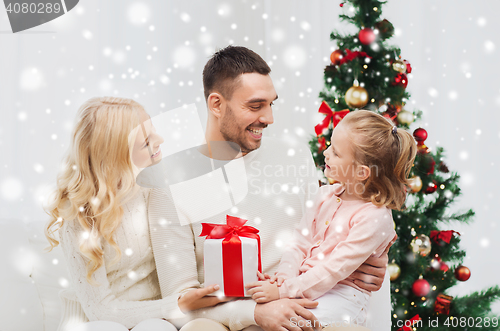 Image of happy family at home with christmas tree