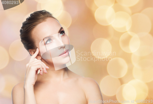 Image of beautiful woman looking up over holidays lights
