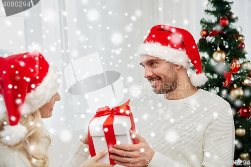 Image of happy couple at home with christmas gift box