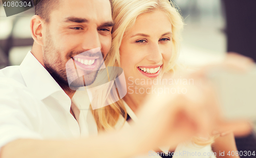 Image of happy couple taking selfie with smatphone outdoors