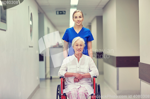 Image of nurse with senior woman in wheelchair at hospital