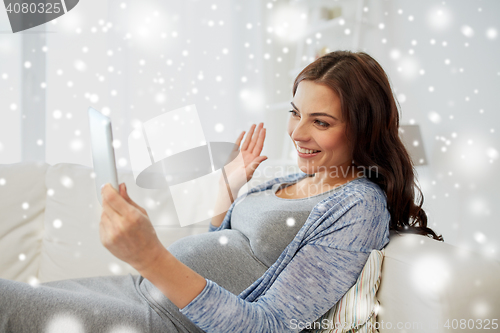 Image of happy pregnant woman with tablet pc at home