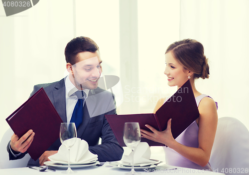 Image of smiling couple with menus at restaurant