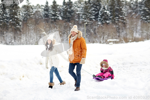 Image of happy family with sled walking in winter forest