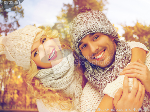 Image of happy couple in warm clothes over autumn