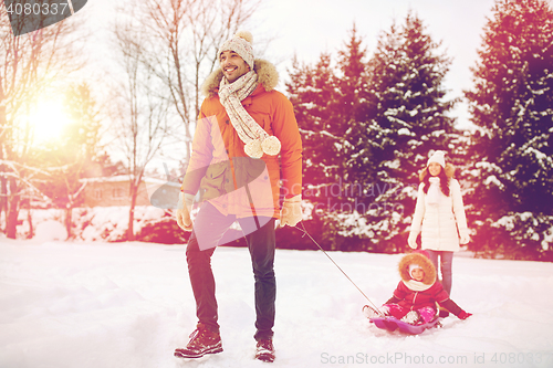 Image of happy family with sled walking in winter outdoors